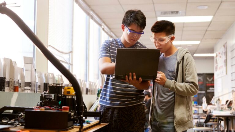 Engineering students working on a laptop with COMSOL software