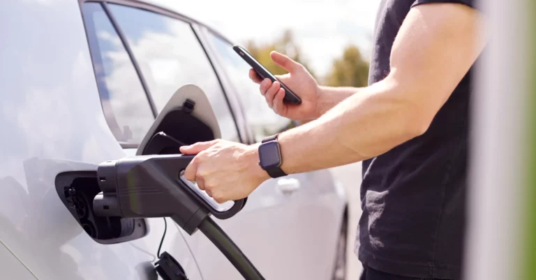 man charging electric vehicle 