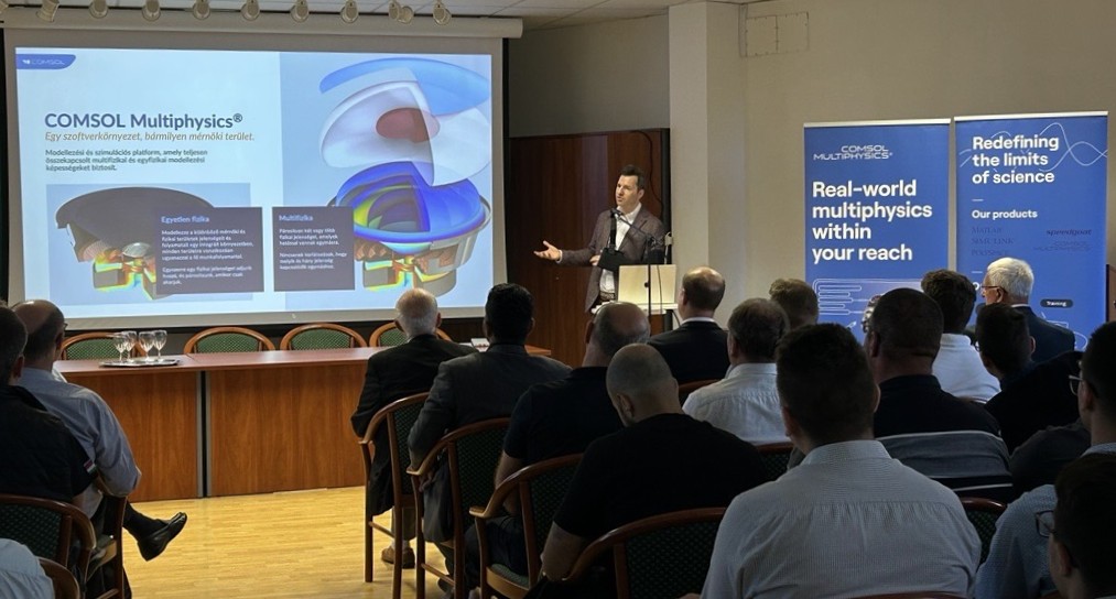 Speaker presenting a talk on welding simulations using COMSOL Multiphysics at a conference.
